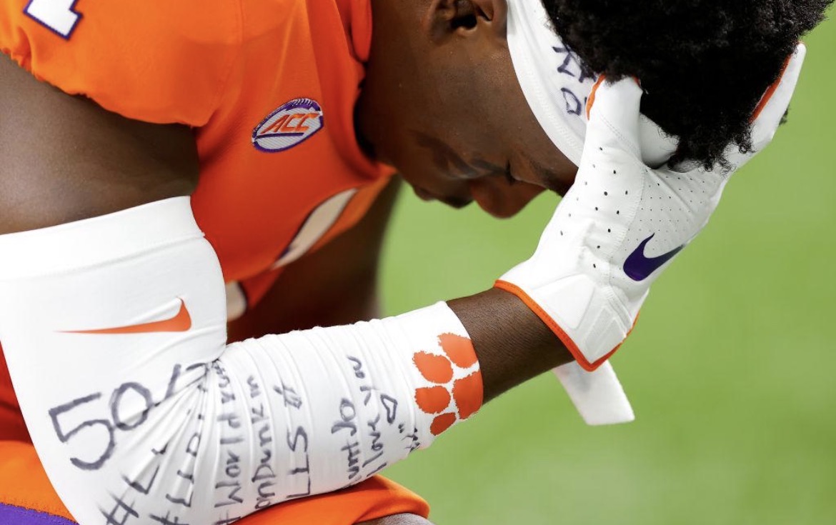 Football player with handwritten reminders covering his sleeve and gloves