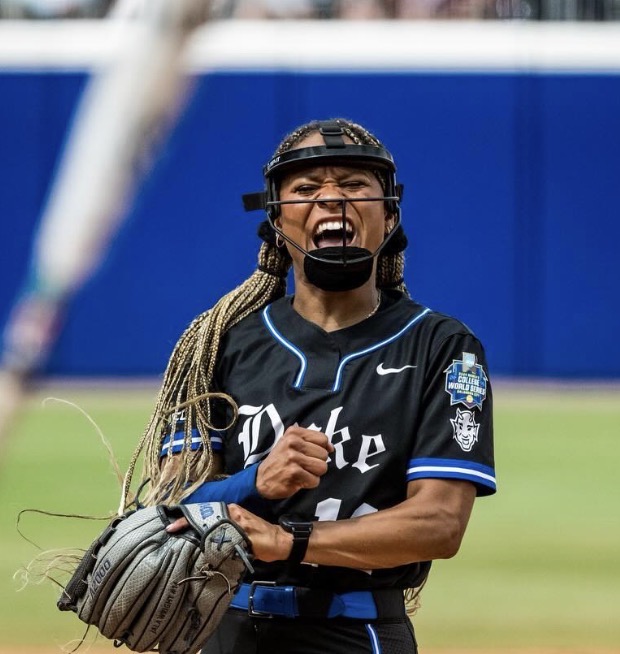 College softball pitcher competing with a written cue on her glove