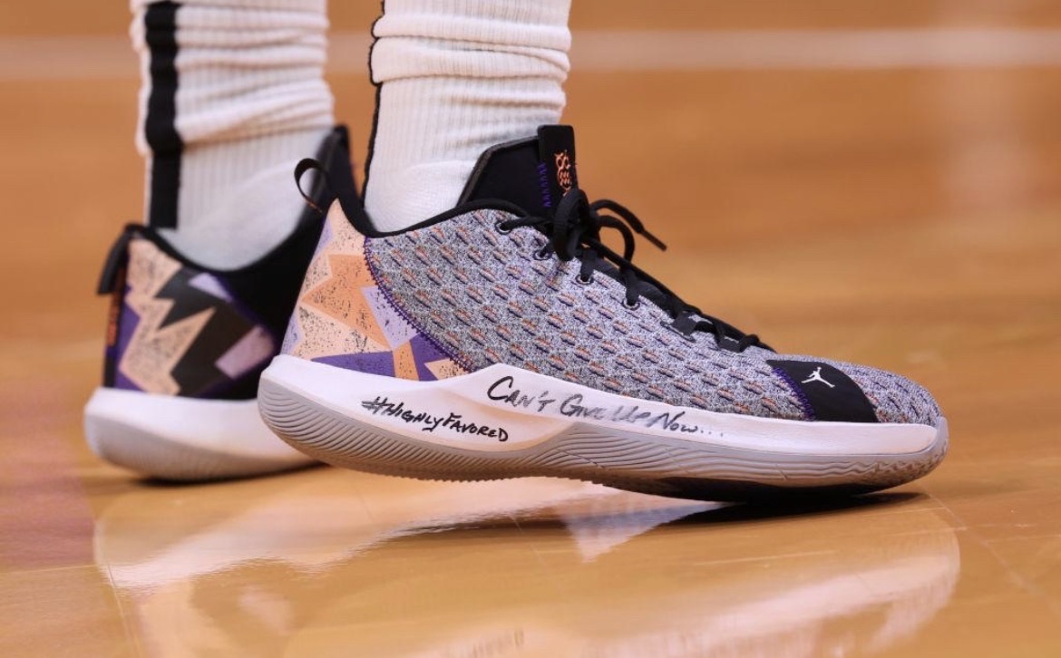 Basketball shoe with 'Can't Give Up Now' handwritten on the sole